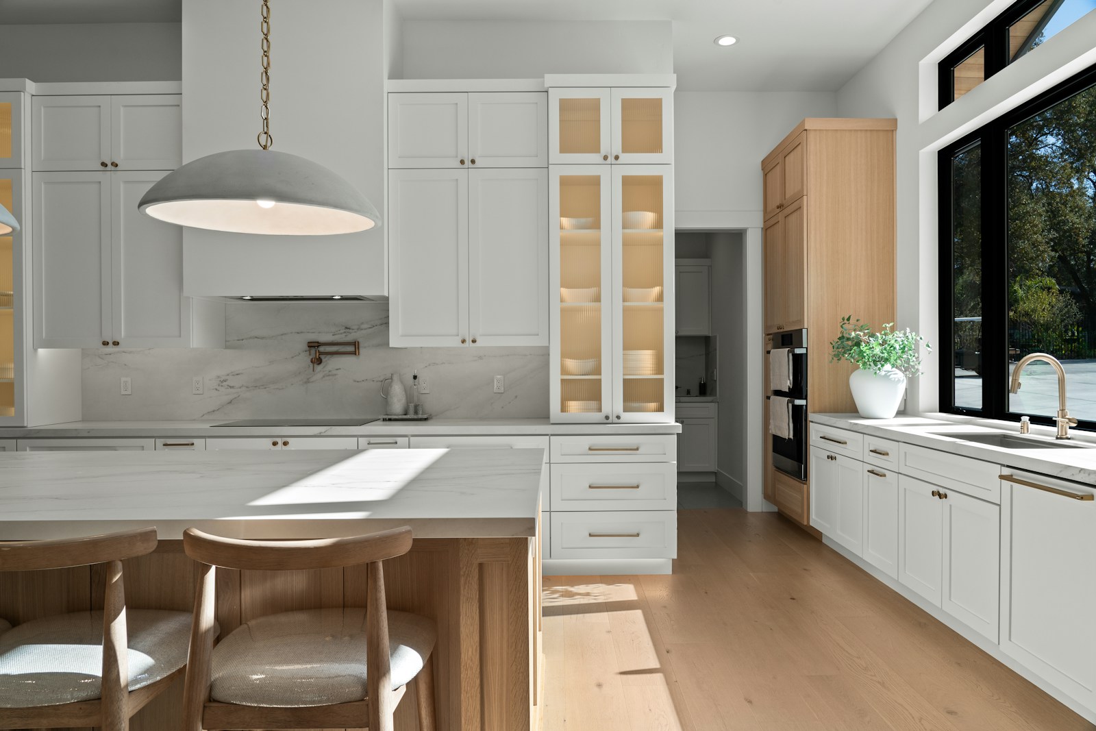 Interior inspiration: a bright kitchen with white cabinetry, oak finishes and brass details.